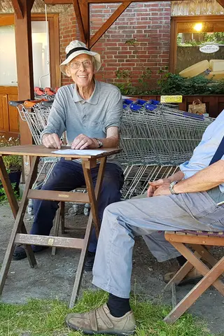 Dieter und Jochen Scharmer sitzen vor dem Hofladen auf Hof Dannwisch 