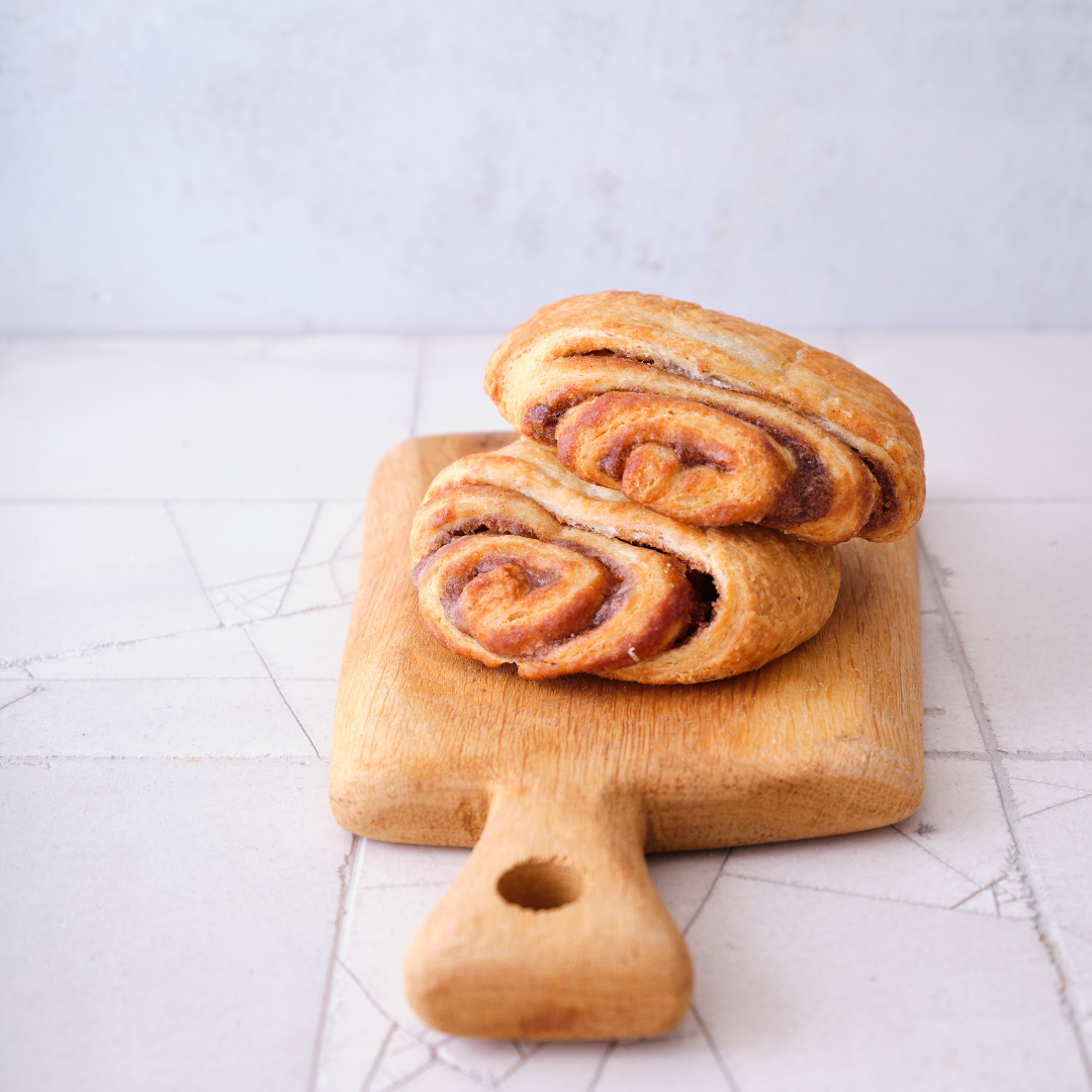 Zwei Franzbrötchen auf einem Holzbrett