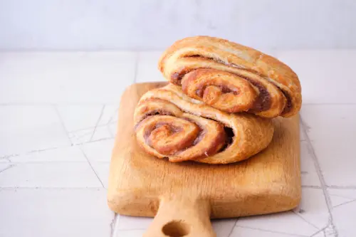 Zwei Franzbrötchen auf einem Holzbrett